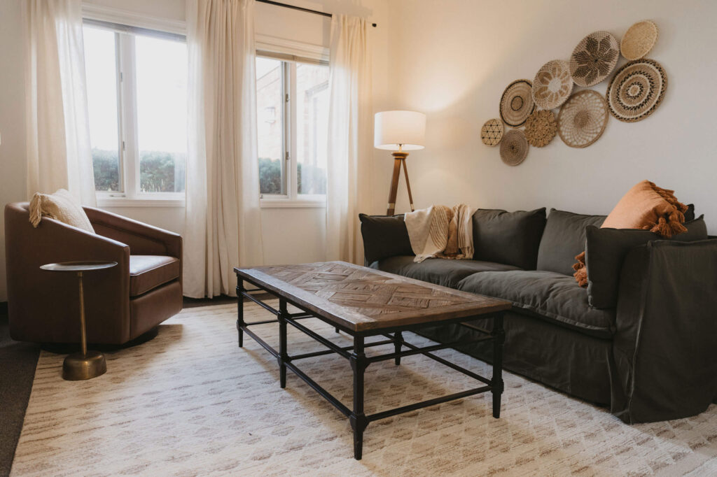 A clinic sitting room with woven baskets on the wall and afternoon light