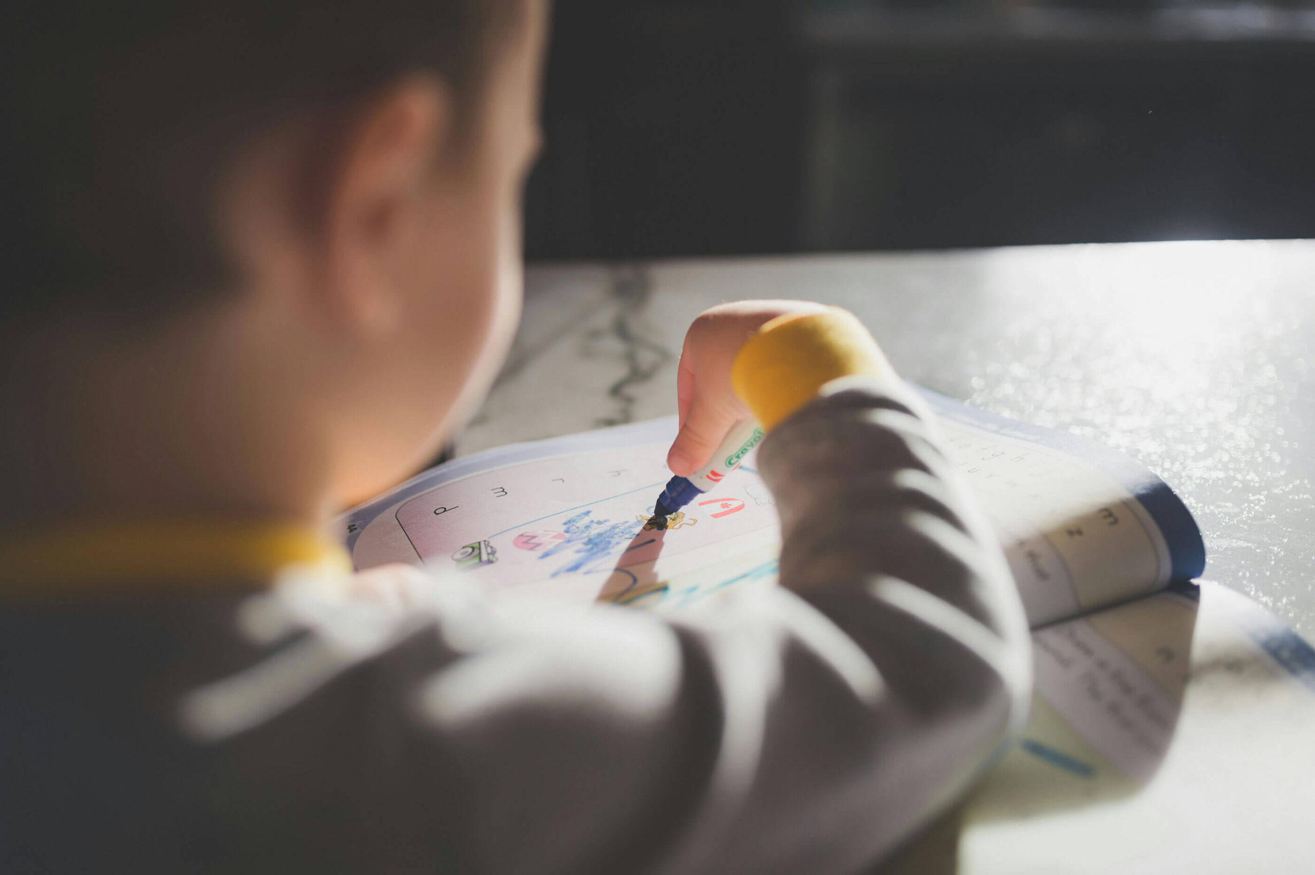 A child drawing with markers, absorbed in the moment